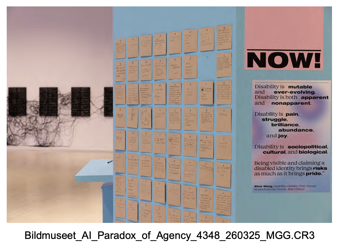 Outside view of the installation, including a dusk pink poster that says 'Disability is mutable and ever-evolving. Disability is both apparent and non-apparent. Disability is pain, struggle, brilliance, abundance, and joy. Disability is sociopolitical, cultural, and biological. Being visible and claiming a disabled identity brings risks as much as it brings pride.'